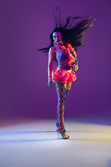 Image showing Attractive hawaiian brunette model on purple studio background in neon light