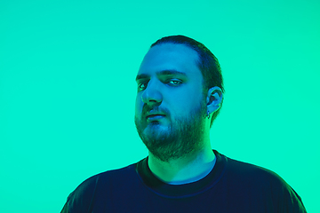 Image showing Portrait of a guy with colorful neon light on green background - cyberpunk concept