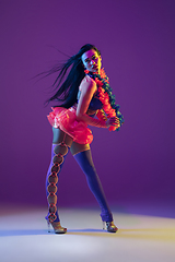 Image showing Attractive hawaiian brunette model on purple studio background in neon light