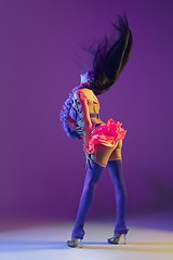 Image showing Attractive hawaiian brunette model on purple studio background in neon light