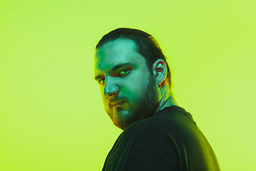 Image showing Portrait of a guy with colorful neon light on green background - cyberpunk concept