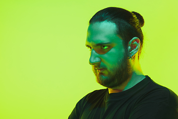 Image showing Portrait of a guy with colorful neon light on green background - cyberpunk concept