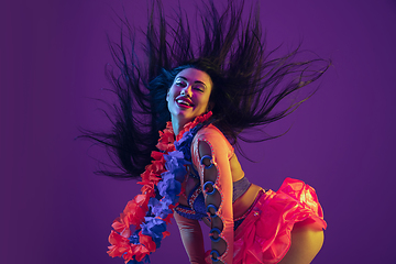 Image showing Attractive hawaiian brunette model on purple studio background in neon light