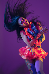 Image showing Attractive hawaiian brunette model on purple studio background in neon light