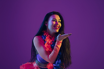 Image showing Attractive hawaiian brunette model on purple studio background in neon light