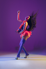 Image showing Attractive hawaiian brunette model on purple studio background in neon light