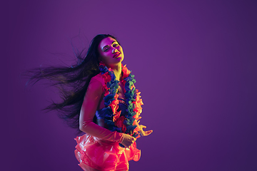 Image showing Attractive hawaiian brunette model on purple studio background in neon light