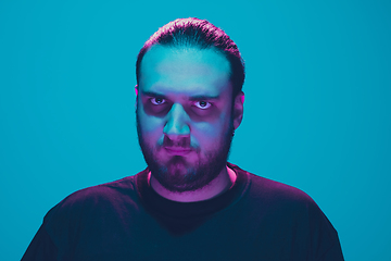 Image showing Portrait of a guy with colorful neon light on blue background - cyberpunk concept