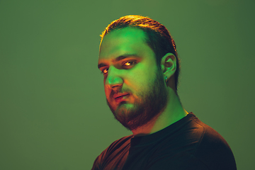 Image showing Portrait of a guy with colorful neon light on green background - cyberpunk concept