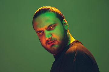 Image showing Portrait of a guy with colorful neon light on green background - cyberpunk concept