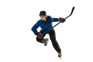 Image showing Young female hockey player with the stick on ice court and white background