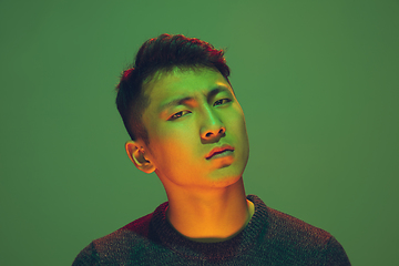 Image showing Portrait of a guy with colorful neon light on green background - cyberpunk concept