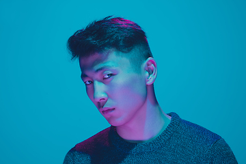 Image showing Portrait of a guy with colorful neon light on blue background - cyberpunk concept