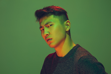 Image showing Portrait of a guy with colorful neon light on green background - cyberpunk concept