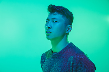 Image showing Portrait of a guy with colorful neon light on green background - cyberpunk concept