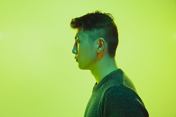 Image showing Portrait of a guy with colorful neon light on yellow background - cyberpunk concept