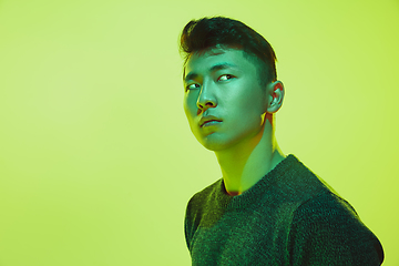 Image showing Portrait of a guy with colorful neon light on yellow background - cyberpunk concept