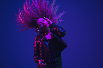 Image showing Caucasian woman\'s portrait isolated on blue studio background in neon light