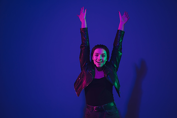 Image showing Caucasian woman\'s portrait isolated on blue studio background in neon light