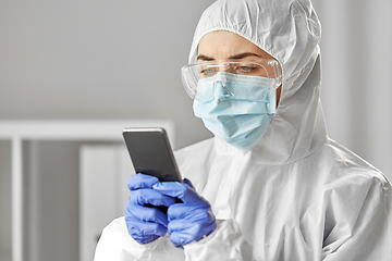 Image showing doctor in protective wear with smartphone