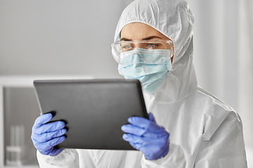 Image showing doctor in protective wear with tablet computer