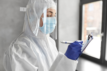 Image showing doctor in medical mask and shield with clipboard