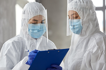 Image showing doctors in medical mask and shield with clipboard
