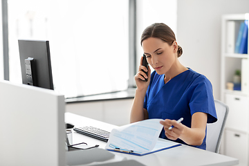 Image showing doctor with computer calling on phone at hospital