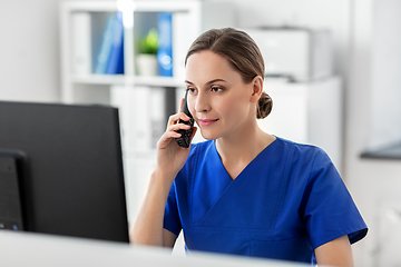 Image showing doctor with computer calling on phone at hospital