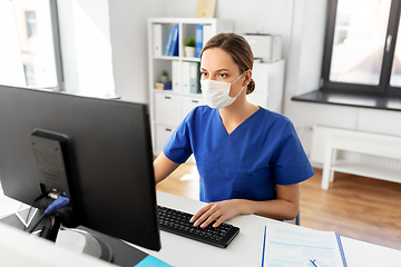 Image showing doctor or nurse in mask with computer at hospital