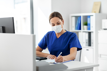Image showing doctor or nurse in mask with clipboard at hospital