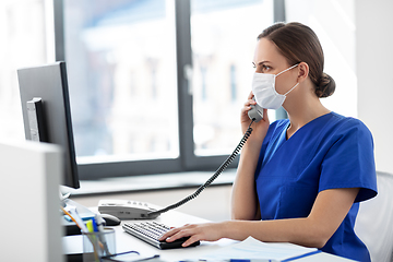 Image showing doctor with computer calling on phone at hospital