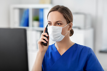 Image showing doctor with computer calling on phone at hospital