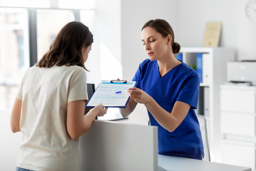 Image showing doctor with clipboard and patient at hospital