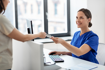 Image showing doctor and patient with credit card at hospital