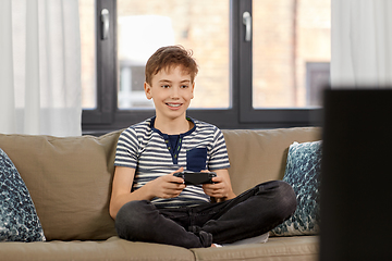 Image showing boy with gamepad playing video game at home