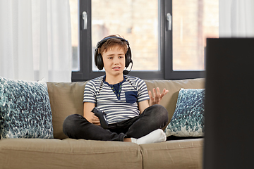 Image showing upset boy with gamepad playing video game at home