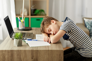 Image showing tired student boy sleeping on desk at home