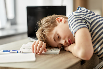 Image showing tired student boy sleeping on desk at home