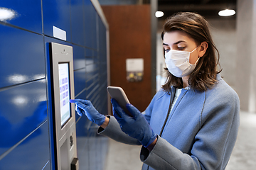 Image showing woman in mask with smartphone at parcel machine