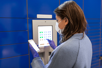 Image showing woman in mask with smartphone at parcel machine