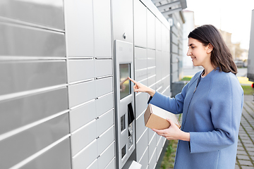 Image showing smiling woman with box at automated parcel machine