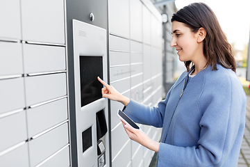 Image showing woman with smartphone at automated parcel machine