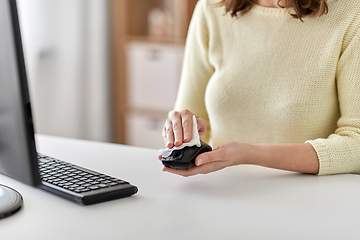 Image showing close up of woman cleaning computer mouse