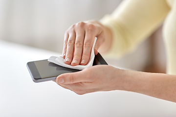 Image showing close up of hands cleaning smartphone with tissue