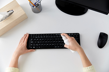 Image showing close up of woman cleaning keyboard with sanitizer