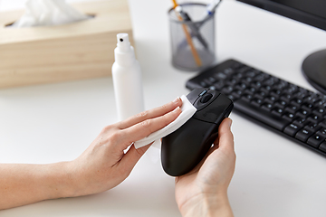 Image showing close up of woman cleaning computer mouse