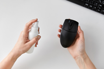 Image showing close up of woman cleaning computer mouse