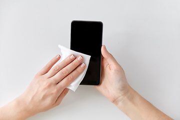 Image showing close up of hands cleaning smartphone with tissue