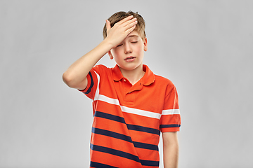 Image showing boy in red polo t-shirt having headache